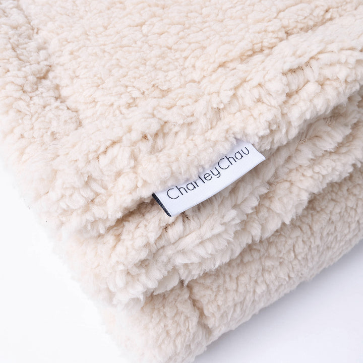 Close up of luxury Sherpa Fleece Dog Blanket in Teddy Beige and Charley Chau brand label