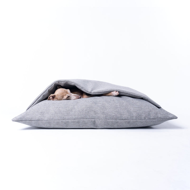 A Dog Snuggle Bed made specifically for dogs that scratch at their beds as part of their nesting ritual. The top of the bed has an insualted duvet cover to keep your dog calm, cosy and content.