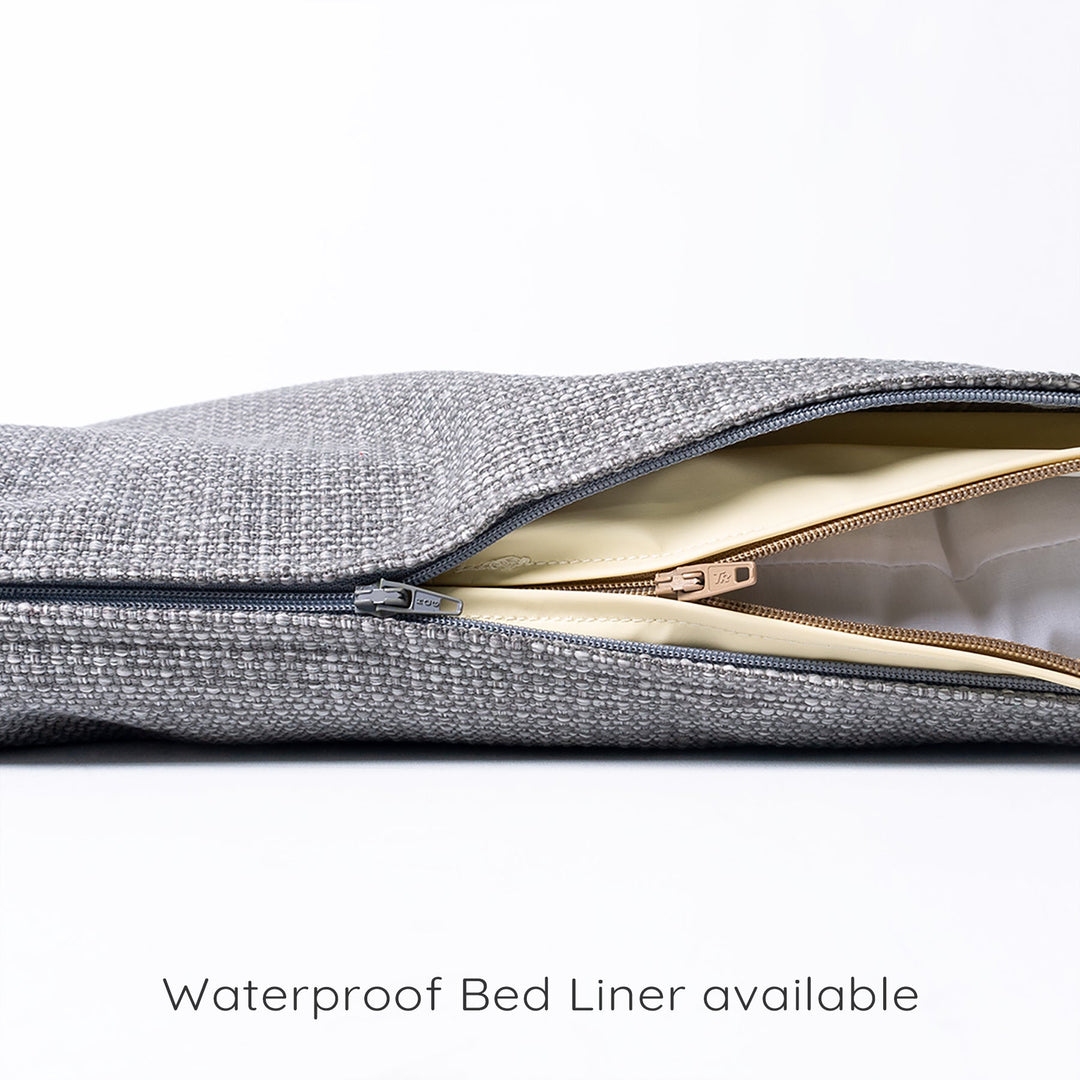 Close up detail of a  lxuury dog travel pad with the zip of the removable cover open to show the internal waterproof dog bed protector and mattress pad.