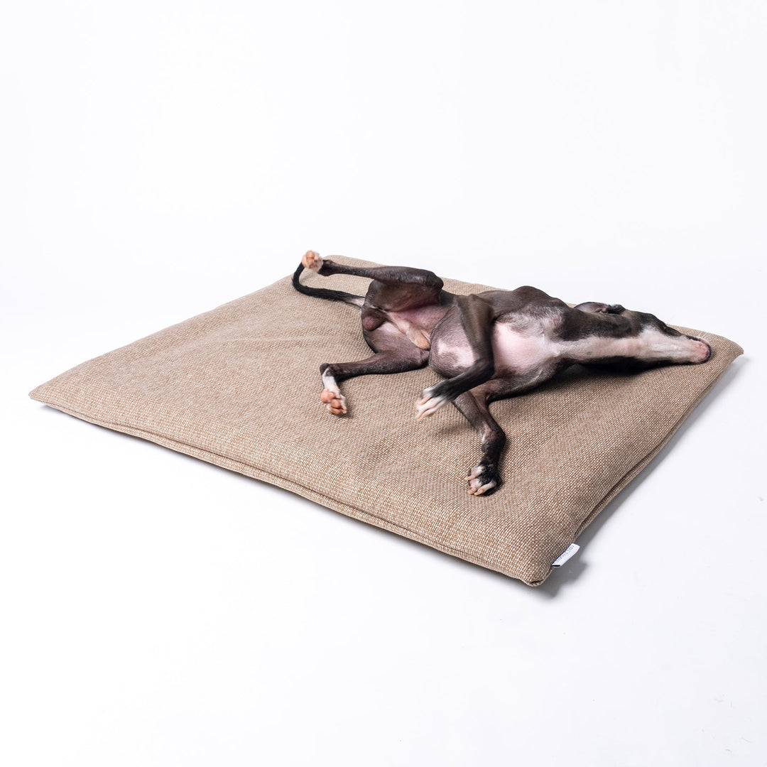 Luxury Dog Travel Pad by designer Charley Chau with a dog lying on top, in Weave II, a textured upholstery fabric in a warm neutral tone called Oak.